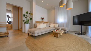 A modern living room with a sofa, coffee table, and a TV. - Beachfront Villa Lara with Pool (Duće)