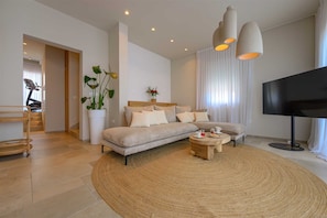 A modern living room with a sofa, coffee table, and a TV. - Beachfront Villa Lara with Pool (Duće)