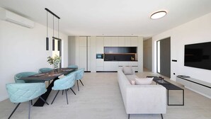 A modern living space with a dining area, sofa, TV, and kitchen. - Luxury Villa Pasman Turquose with Pool (Tkon)