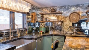 Uma cozinha moderna com bancada de mármore, eletrodomésticos de aço inoxidável e objetos decorativos.