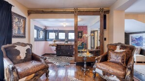 A room with two antique leather chairs, a wooden desk, a zebra-patterned rug, and a large mirror. - Walk to Park City Mountain Ski Resort & Main St The House in Woodside Ave by Avantstay (Park City)