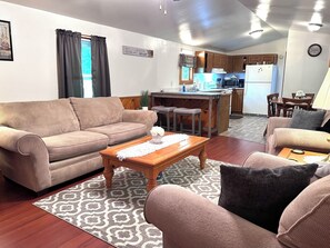 Ein Wohnzimmer mit einer Couch, einem Couchtisch und einem gemusterten Teppich.