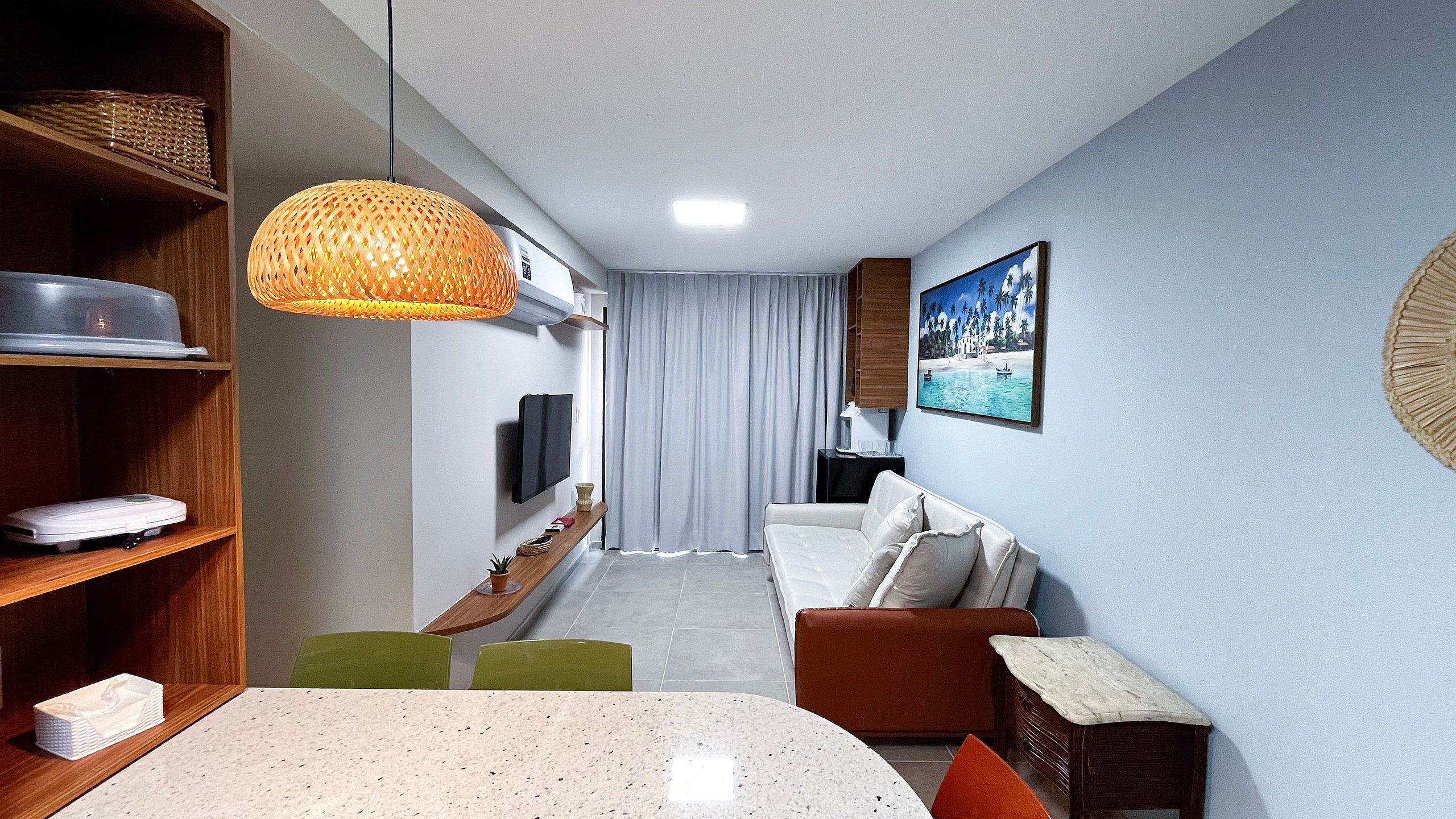 A modern living room with a TV, sofa, and dining table.