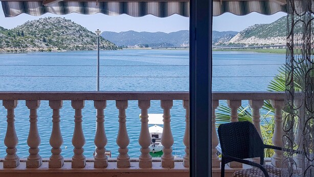 A balcony with a view of a lake and mountains.