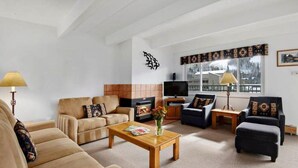 A spacious living room with a fireplace, sofas, a coffee table, and a television. - Amazing Lionshead 2 bd/2ba condo. Walk to slopes and shops. Amazing Hot Tub! (Vail)