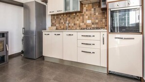 A modern kitchen with stainless steel appliances, white cabinetry, and a tiled backsplash. - Amazing Villa with Outdoor Swimming Pool (Stankovci)