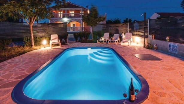 A swimming pool with lounge chairs and a building in the background. - Amazing Villa with Outdoor Swimming Pool (Stankovci)