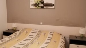 Et soveværelse med en seng, to sengeborde og et billede hængende på væggen.
