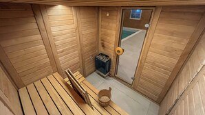 Et sauna-rum med træbænke og en spand.