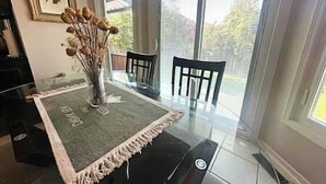 A dining area with a table, chairs, and a vase of dried flowers. - Luxury 4BR Home Near Square One, with King Bed (Mississauga)