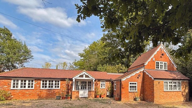 Un bâtiment en briques doté d’un toit à pignon et de nombreuses fenêtres.