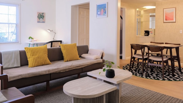 A modern living room with a sofa, coffee table, and dining area. - Quiet & Modern. Close to WFU-Reynolda. Patio Fenced. (Winston-Salem)