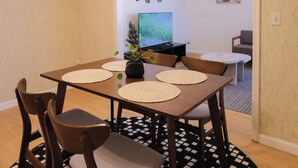 A dining area with a rectangular table, four chairs, and a small potted plant. - Quiet & Modern. Close to WFU-Reynolda. Patio Fenced. (Winston-Salem)