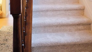 A carpeted staircase with wooden balusters and a white door at the top. - Quiet & Modern. Close to WFU-Reynolda. Patio Fenced. (Winston-Salem)