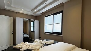 Una habitación de hotel con cama, un espejo grande, un armario y una ventana con persianas.