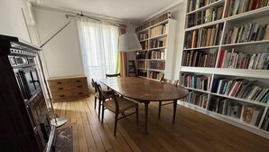 A room with a wooden table, chairs, a bookshelf, and a window with curtains. - WITHIN WALKING DISTANCE, SAINT GERMAIN AS LES INVALIDES, THE RODIN MUSEUM, (Paris)