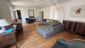 A living room with a sofa, a chair, a lamp, and a wooden cabinet. - WITHIN WALKING DISTANCE, SAINT GERMAIN AS LES INVALIDES, THE RODIN MUSEUM, (Paris)