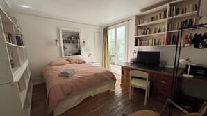 A bedroom with a bed, a desk, a chair, a bookshelf, and a mirror. - WITHIN WALKING DISTANCE, SAINT GERMAIN AS LES INVALIDES, THE RODIN MUSEUM, (Paris)
