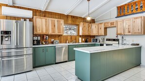 A modern kitchen with wooden cabinets, stainless steel appliances, and a large island. - Seymour Lake Across St! Scenic Home w/ Hot Tub (Morgan)