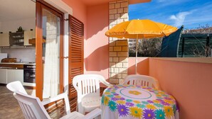 A balcony with a table, chairs, and an umbrella. - 2 bedroom lovely apartment in Pag (Pag)