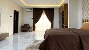 Um quarto moderno com uma cama grande, uma área de estar e um guarda-roupa.