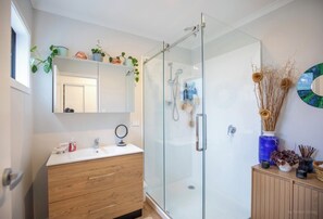 Shower, hair dryer, towels, soap - Modern Family-Friendly Sunny Raglan Bach with Spa Pool, BBQ & Large Deck (Raglan)