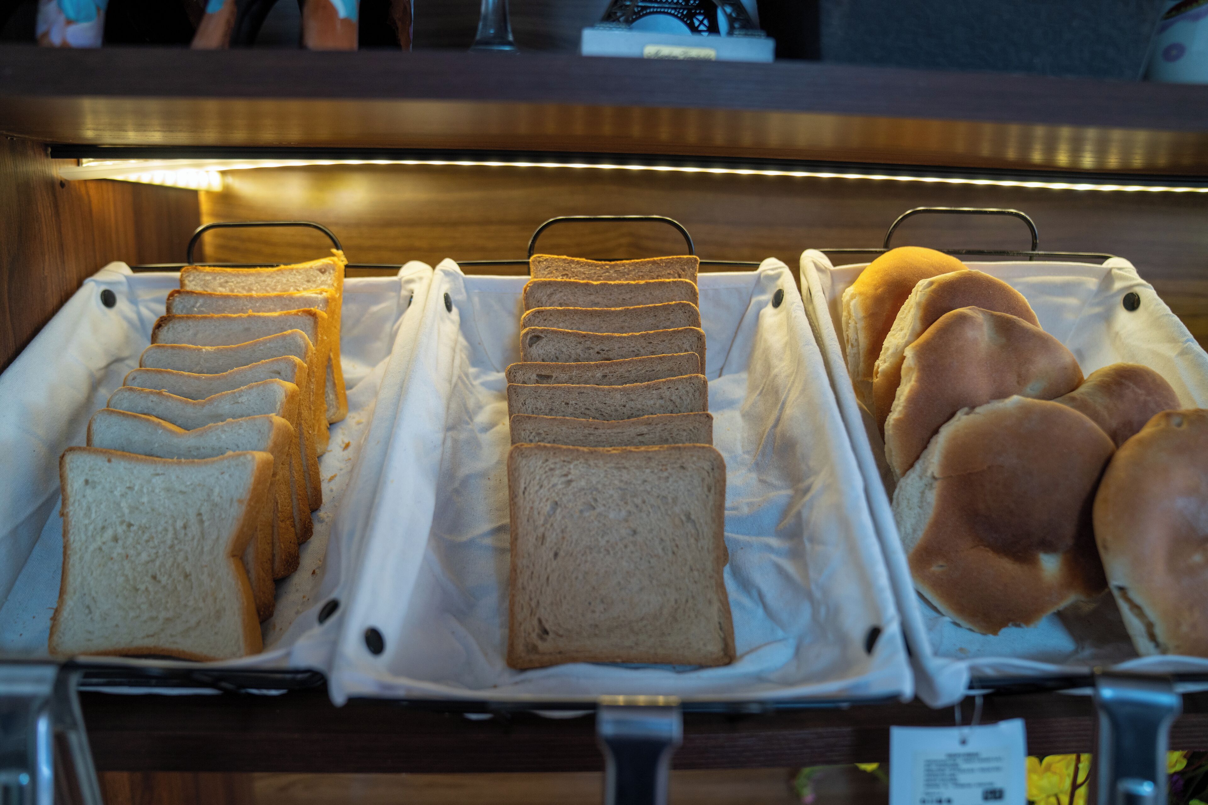 A bakery display with various types of bread and rolls.