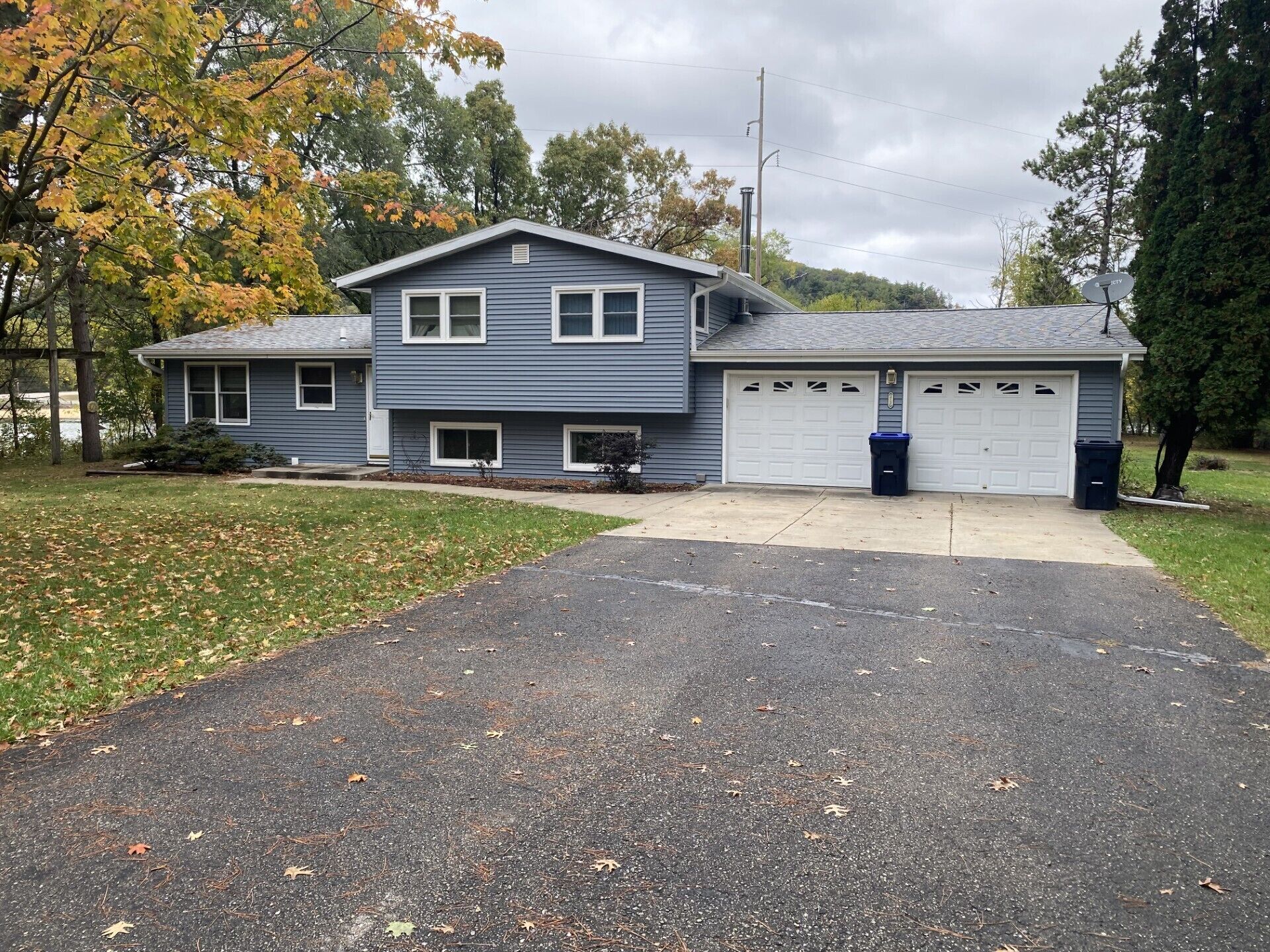 Une maison à deux étages avec un garage, une allée et une pelouse.