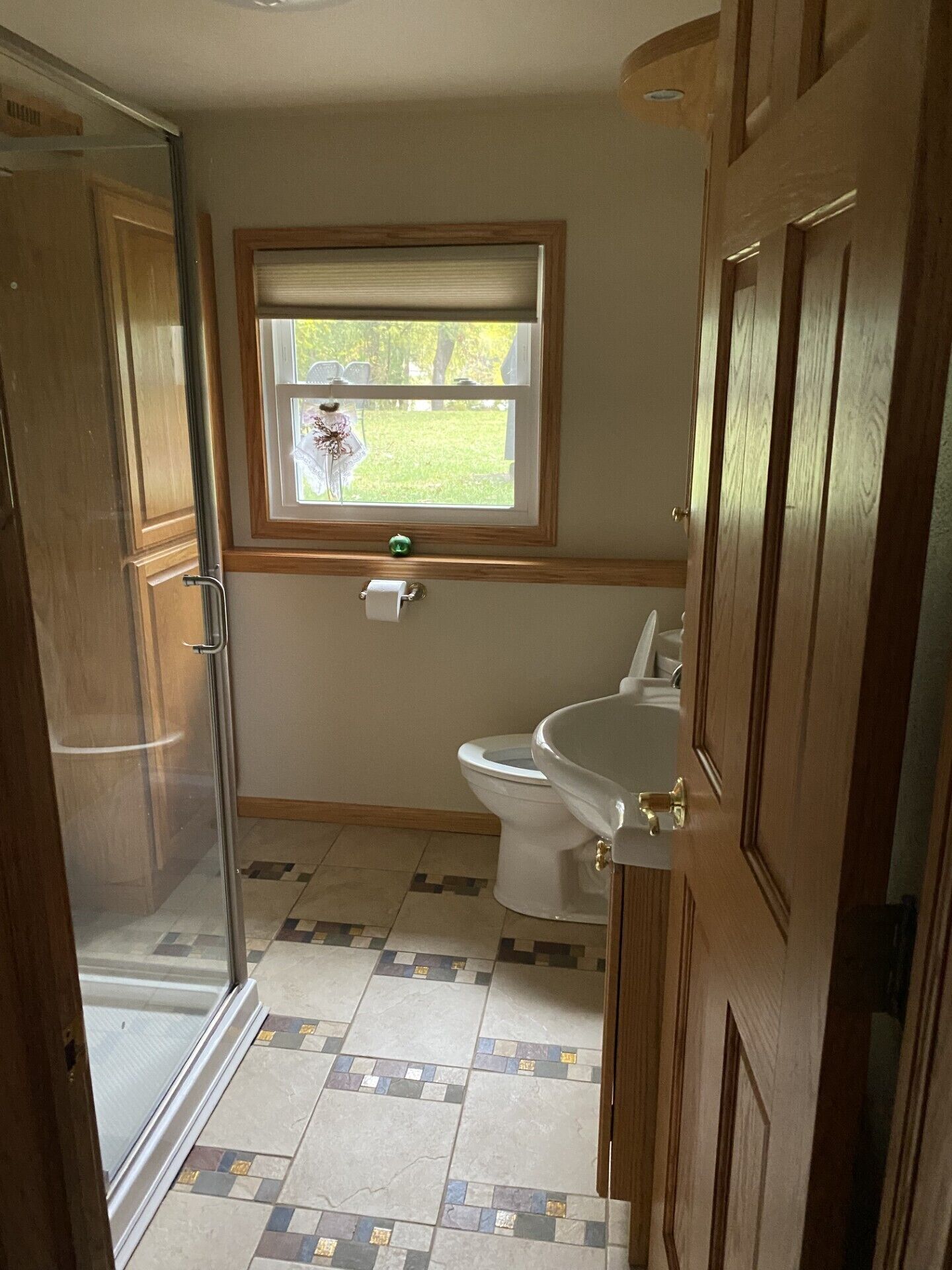 Een badkamer met toilet, douche en raam.