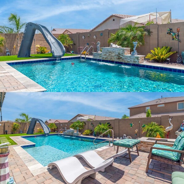 A swimming pool with a slide, lounge chairs, and decorative statues. - Goodyear Retreat, Pool, Slide, Firepit, BBQ (Goodyear)