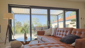 A modern living room with a leather sofa, a glass coffee table, and a tripod lamp. - Villa in Paradise With Heated Pool (Sveta Nedelja)