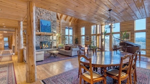 A spacious log cabin interior with a fireplace, dining area, and large windows offering mountain views. - Sleeps 20, Secluded 7bdr Retreat on 71 Priv Acres Elkstone Lodge by Avantstay (Glenwood Springs)
