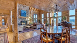 A spacious log cabin interior with a fireplace, dining area, and large windows offering mountain views. - Sleeps 20, Secluded 7bdr Retreat on 71 Priv Acres Elkstone Lodge by Avantstay (Glenwood Springs)