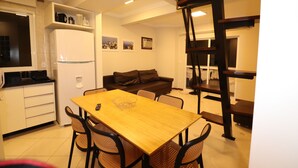 Un espacio habitable compacto con cocina, comedor y escalera.