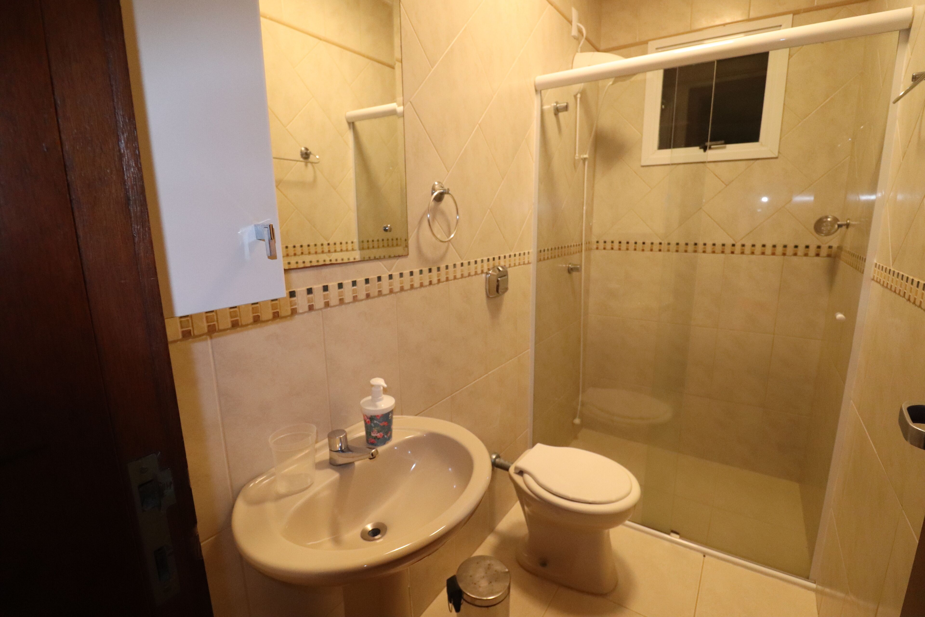 Een badkamer met een wastafel, toilet en douchecabine.