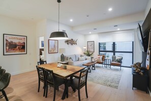 Una sala moderna con una mesa de comedor de madera, asientos cómodos y un ventanal con vistas.