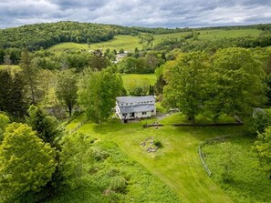 A large house surrounded by lush green fields and trees. - Country Chic 3BR Retreat Near All Star Village (Treadwell)