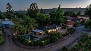 A residential area with houses, a swimming pool, and a road curving through the landscape. - Trentadue Winery Farmstay with Pool and Wine Tastings Included (Geyserville)