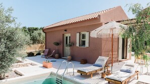 A poolside area with lounge chairs, a small pool, and a building with a tiled roof. - Villa Nerithra, Private Pool and Garden, Furnished Terrace, Vathy, Ithaca (Ithaca)
