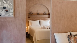 A bedroom with a bed, a sofa, and a wall-mounted shelf with scales. - Villa Nerithra, Private Pool and Garden, Furnished Terrace, Vathy, Ithaca (Ithaca)