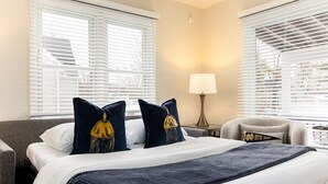 A hotel room with a bed, two pillows, a lamp, and a chair. - Emerald Clover<>3BR, 1Bath House- 1 mile from ND (South Bend)