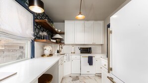 A modern kitchen with white cabinetry, a built-in oven, and a window with a view. - Emerald Clover<>3BR, 1Bath House- 1 mile from ND (South Bend)