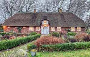 A traditional brick house with a thatched roof, a central door, and a small porch. - 2 bedroom beautiful home in Galmsbüll (Galmsbüll)