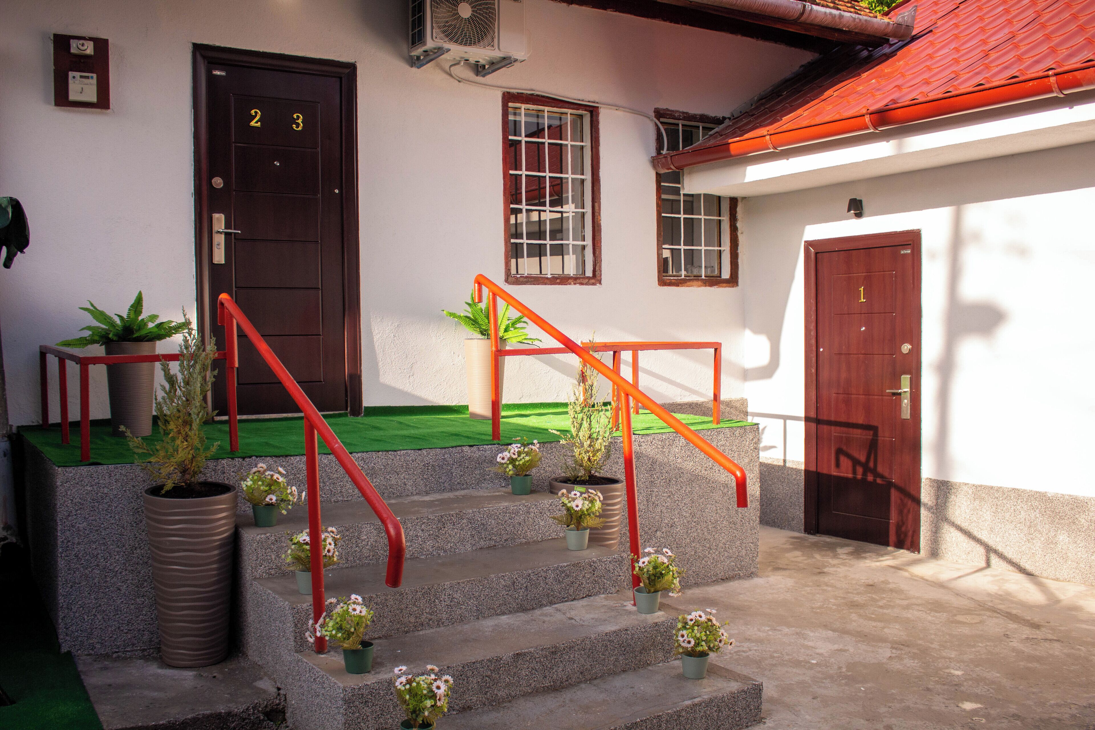 Un edificio con una escalera, una puerta con la etiqueta '2' y una puerta con la etiqueta '1'.