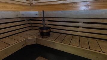 A sauna with wooden benches and a central heating element.