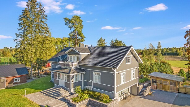 A large two-story house with a stone foundation, a covered patio, and a well-maintained lawn. - Villa torppa by Interhome (Eura)