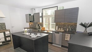 A modern kitchen with dark countertops, a central island, and built-in appliances. - Villa torppa by Interhome (Eura)
