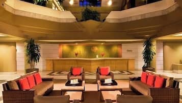 A lobby with wicker sofas, a reception desk, and a decorative wall.