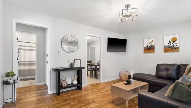 A modern living room with a sofa, coffee table, and artwork on the wall. - Cozy&Convenient Modern Home • Private Fenced Yard (Springfield)