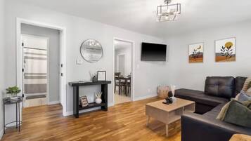 A modern living room with a sofa, coffee table, and artwork on the wall.